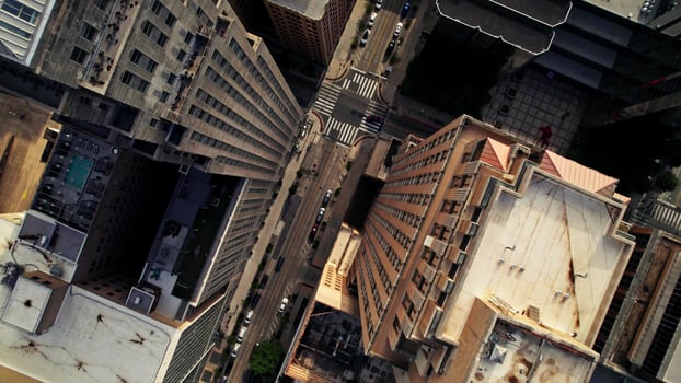 The drone flies over the roofs of the skyscrapers of an American city. Cars drive through the streets between the houses photo