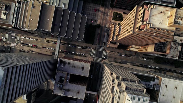 The drone flies up and circles over the roofs of skyscrapers of an American city. Cars drive through the streets between the houses photo
