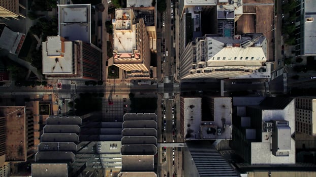 The drone flies over the roofs of the skyscrapers of an American city. Cars drive through the streets photo