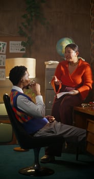 A man is talking to his colleague and drinking coffee sitting in a retro office. photo