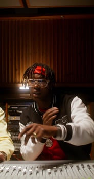 The singer listens to his song while sitting near an audio mixer in a recording studio. He's talking to the sound engineer. photo