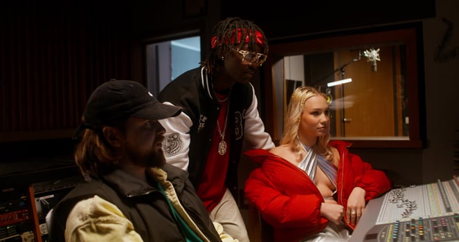 The sound engineer talks to the musicians after recording the song in the studio. They are sitting in front of the equipment photo