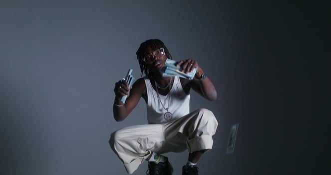 A man in white pants and a white tank top is holding a knife photo