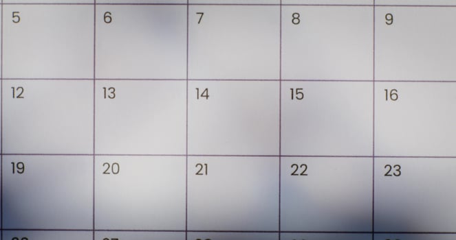 A woman crosses out a date on a calendar photo