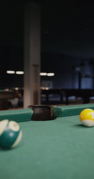 A billiard ball flies into the hole, close-up. No people in the , just a pool table, vertical - billiard photo