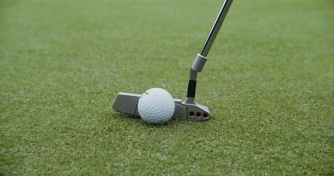 A golf club hits a ball, close up, no people. Details of golf on a neatly sloped golf course photo