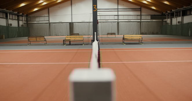 Young athletes a man and a woman of European appearance greet each other, with a handshake through a net stretched in the middle of a tennis court photo
