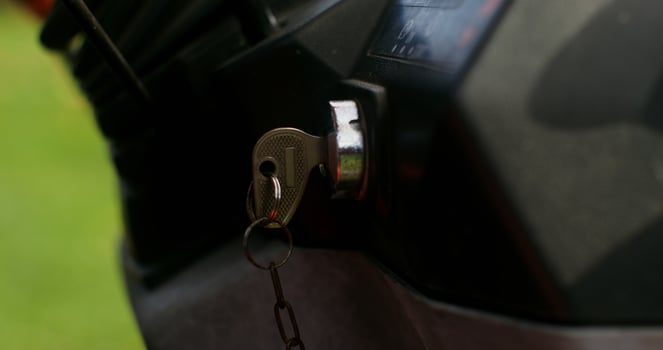 Close up of a key in a tractor ignition switch. Male hand turns the key, starting the agricultural machine photo