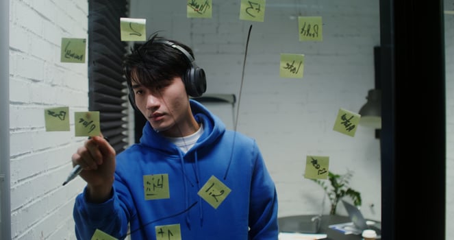 A man wearing headphones and holding a pen photo