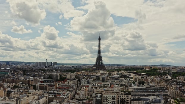 The spire of the Eiffel Tower among fluffy white clouds rises above the historical center of Paris. City cityscape, drone , France - clouds photo