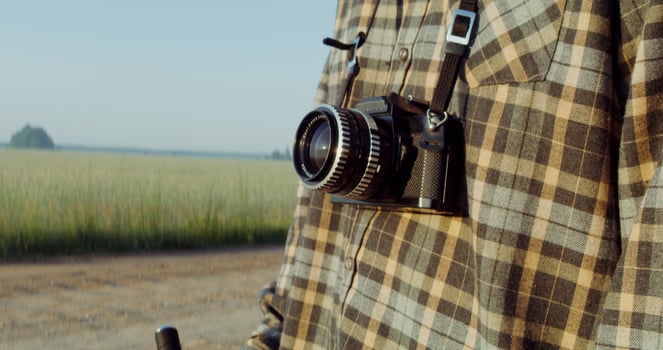 A young man with a camera hanging around his neck photo