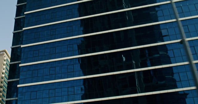 Dubai, UAE, 2025- Glass facades of skyscrapers in the modern city center. Construction of modern buildings, bottom view photo