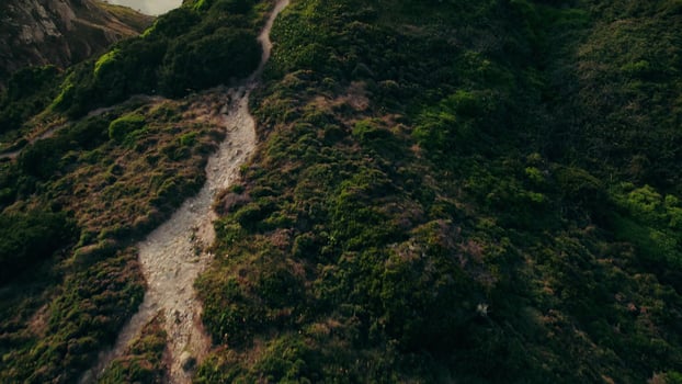 The top of the mountain to the sea with a sandy beach and a rocky reef near the shore. Bird's-eye view on a summer day photo