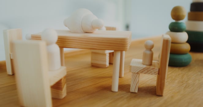 Wooden toys of natural shades are on the table in a bright interior, there are no people photo