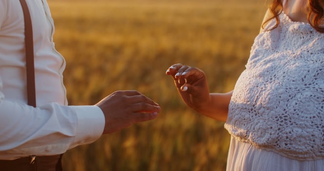 The bride puts a ring on the groom's finger, close-up of the hands - Scene 3 photo