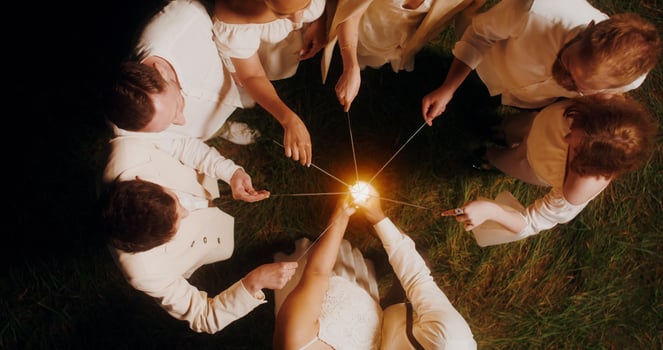 Top view of the guests lighting sparklers and start dancing with them around the bride and groom, wedding concept photo