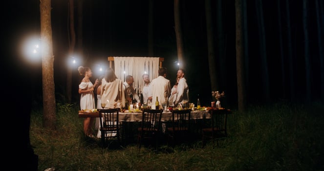 Elegant guests smile and dance at an outdoor party at night photo