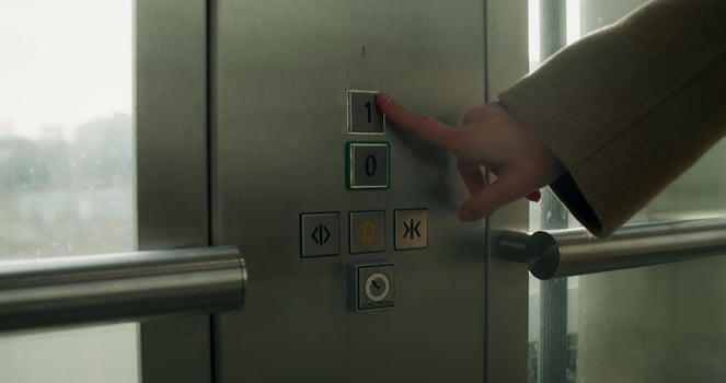 A woman presses the floor selection button in an elevator, close-up of her hand, an unrecognizable person - unrecognizable photo