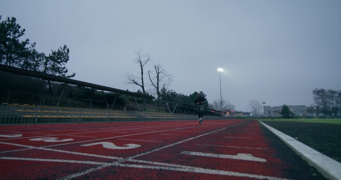 A man in sports clothes runs around the stadium on a cold day alone photo