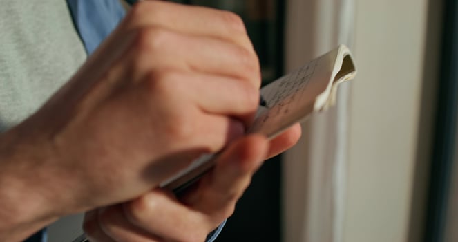 A person is holding a piece of paper and writing on it photo