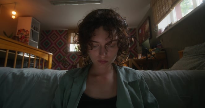 A young woman uses a laptop sitting on the floor in the bedroom at home with a serious look - laptop photo