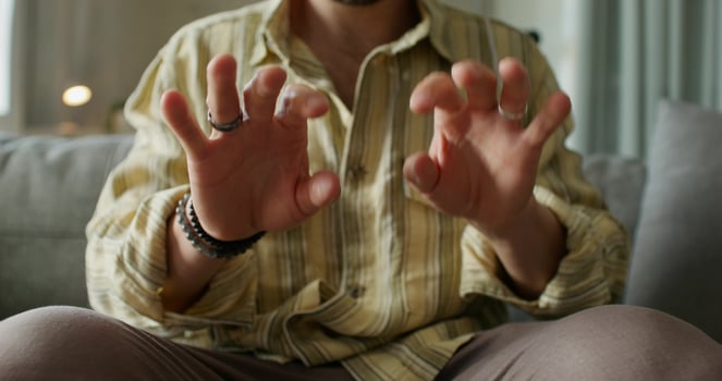 A man is sitting on a couch and making gestures photo