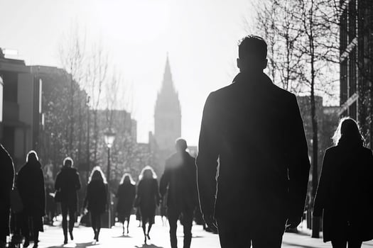 A black and white photo of people walking down a street