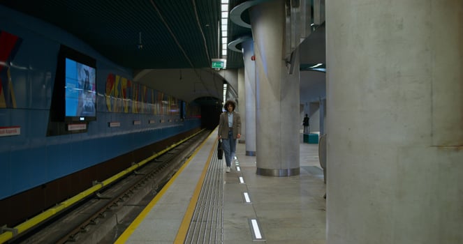 A train is parked at a train station with a person walking by photo