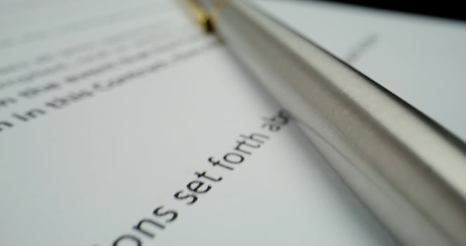 A pen on a paper with a contract photo