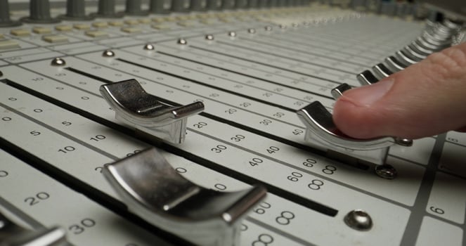 A person is touching a mixing board photo