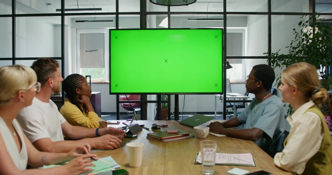 Group of people in a meeting room with a green screen photo