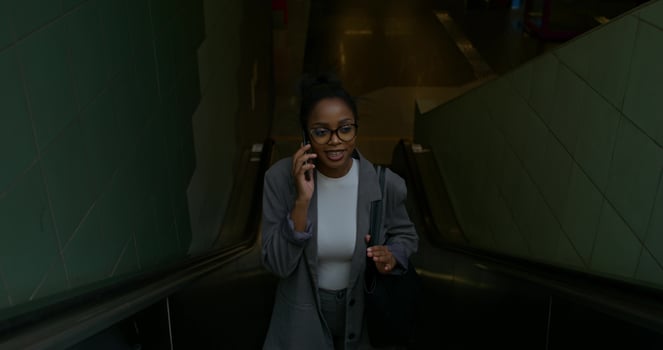 A woman in glasses and a suit talking on her phone photo