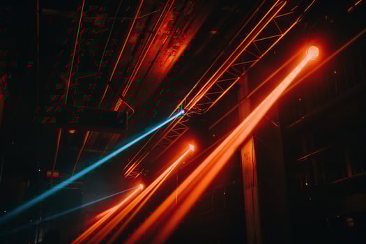 Stage lights illuminating dark venue. Red and blue beams crisscrossing photo