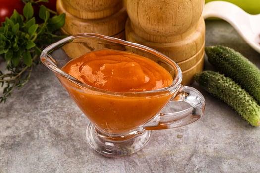 A glass jar filled with a tomato sauce photo