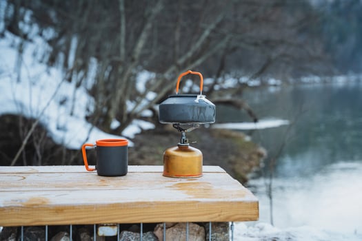 A sturdy wooden table equipped with two ceramic cups and a functional gas stove placed thoughtfully on it, creating a cozy kitchen setup perfect for any culinary endeavor photo
