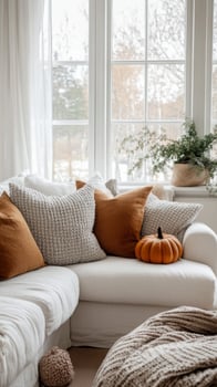 A white couch with orange and white pillows photo