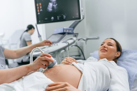 Close, up view,, scanning. Pregnant woman is lying down in the hospital, doctor does ultrasound photo