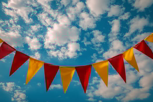 Red, yellow and blue bunting against a blue sky photo