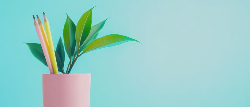 A vase with pencils and a plant on a blue background photo