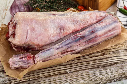 Raw meat on a wooden table with vegetables photo
