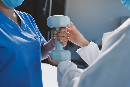A doctor is holding a dumbbell while another person is holding a mask photo