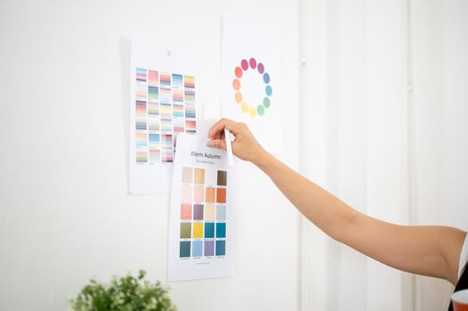 Close up of a hand sticking or taking off a printed color palette on the wall, Designer in office. photo
