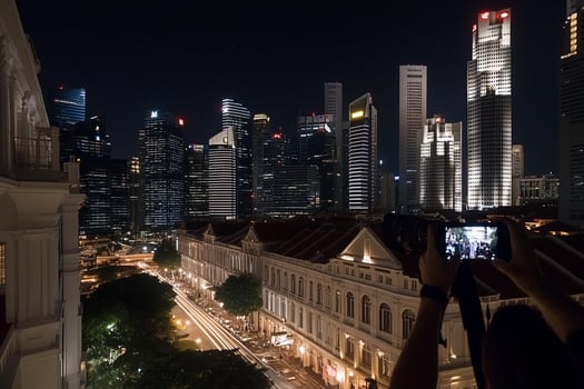 A person taking a picture of the city at night photo