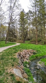 Winding path along a stream in pruhonice park, czechia photo