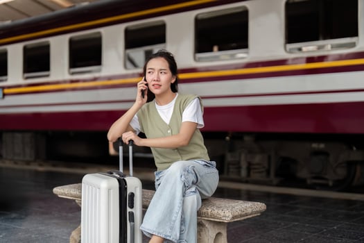 Travel and Connectivity. A woman talking on the phone at a train station. photo