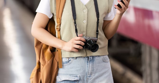 Exploration and Creativity. A woman capturing travel moments at the train station. photo