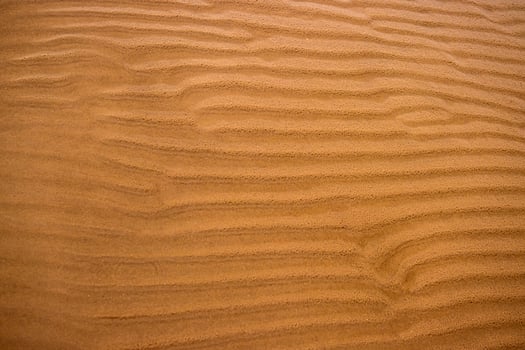 Closeup of sand ripples on a beach. Natural rhythmic wave like pattern formed by wind and water. Textured background displaying the delicate wavy texture of coastal landscape 02 photo