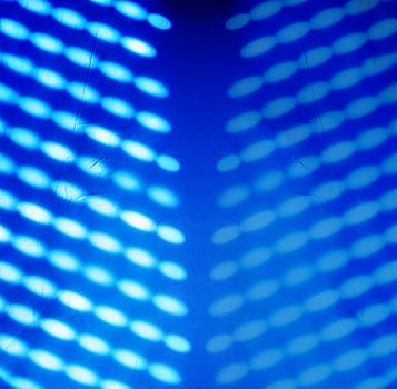 Blurred light spots, shadows from the blinds on the concrete wall, creating creating a glowing effect with a soft, futuristic texture, ideal for backgrounds and creative design. Copy space 02 photo