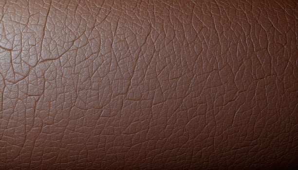 The surface of weathered leather, displaying cracks, creases, and signs of wear. photo