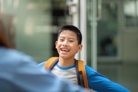 Back to School and Connection. A son expresses joy as he opens his arms to his mother. photo